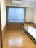 フローリング仕様の小さなワンルームタイプの部屋。介護用ベッドが置いてある様子