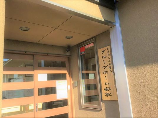 「グループホーム安寧」の看板があるエントランス付近の様子。和風デザインの玄関
