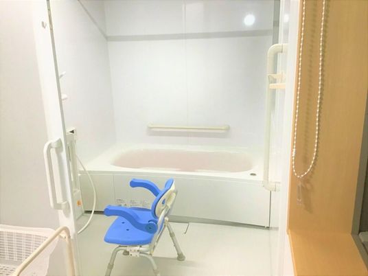 シャワーチェアが置いてある介護仕様の浴室。家庭によくあるサイズの浴槽