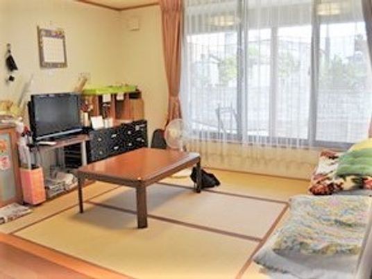 窓がある一角に畳のこ上りが設けられている。テレビ、テーブル、ソファなどがある家庭的なサイズの和室こあがり