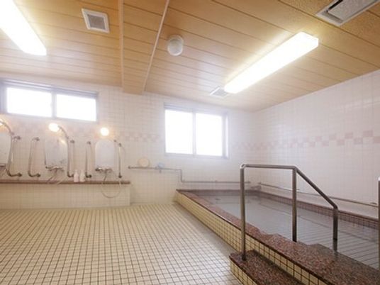 大きな浴槽が設置された浴室にはたくさんの窓があり、壁とフロアにはタイルが貼られ、シャワースペースもある。