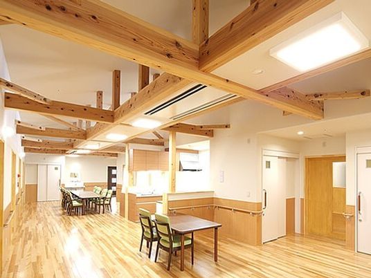 木材をふんだんに使用した広々とした館内。ダイニングテーブルが複数置かれている。