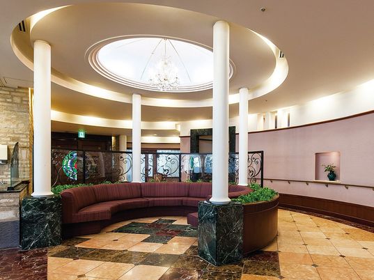 丸いホール・ロビーのような場所を写したもの。手すりがついた壁がある