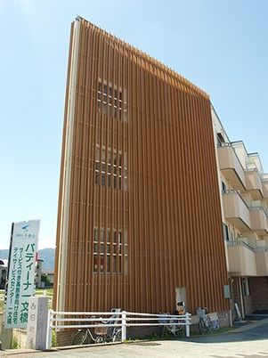 背の高い鉄骨造の建物の外観。パティーナ一文橋の外観を写したもの