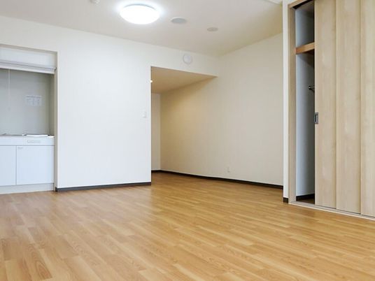 シンプルなフローリングの部屋には備え付けのクローゼットとキッチンがあり、家具などはない。