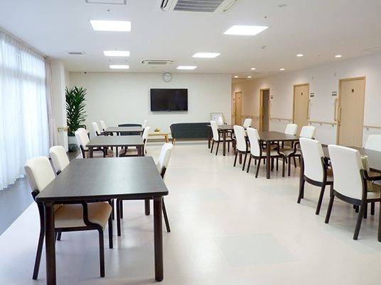 食堂にはモノトーンのダイニングセットがあり、奥にはテレビスペースがある。