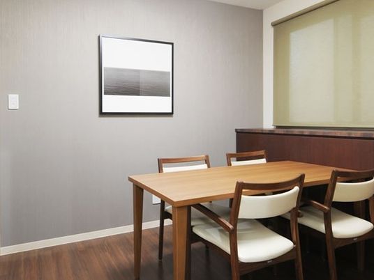 木製のテーブルと椅子が置いてある小さな部屋の様子。会議室内の写真