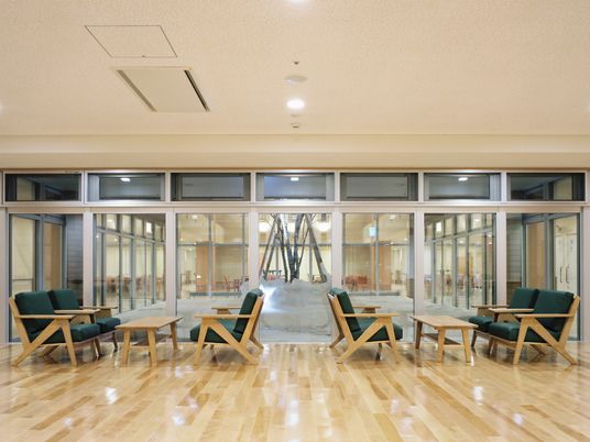 広めのリラックススペースにソファや机が置いてある様子。バリアフリーの床