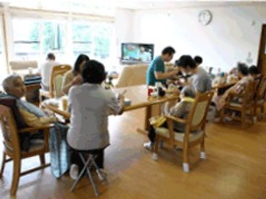 食事をしているグループホーム内のリビングの様子。施設内の一場面の写真