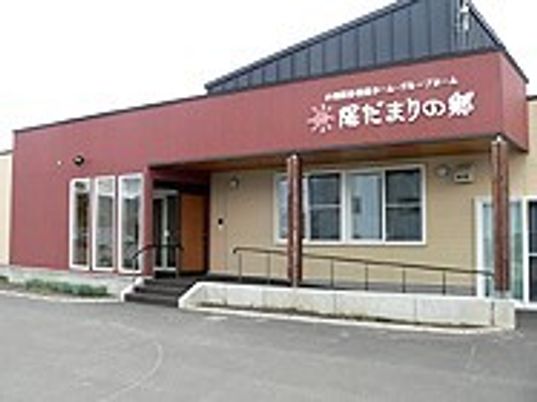 平屋建ての建物の外観写真。車いす用のスロープがついているのがわかる