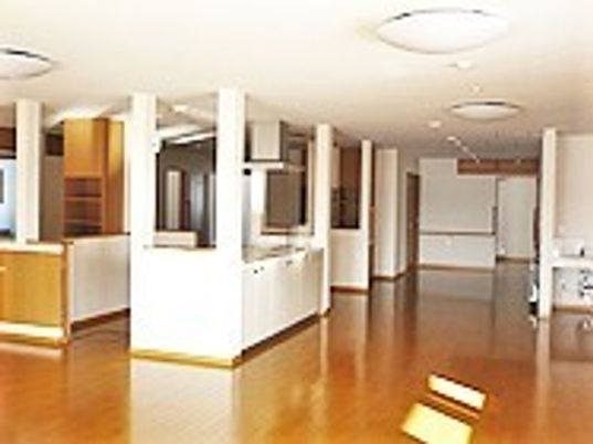 フローリング仕様の施設内を写した写真。火の光が差し込んでいる様子