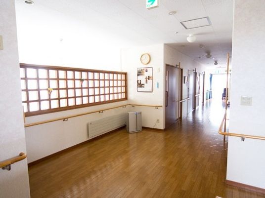 幅広い廊下には手すりが設置され、両サイドに居室がある。突き当たりには窓があり明るい。
