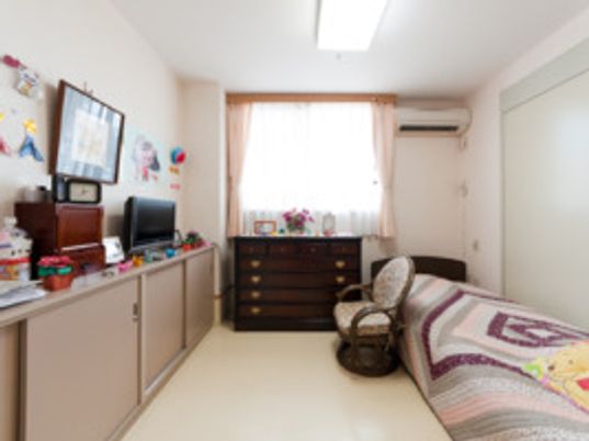 寝具付きのベッドやエアコン、テレビなどが置かれた部屋にはたくさんの装飾品が飾られている。