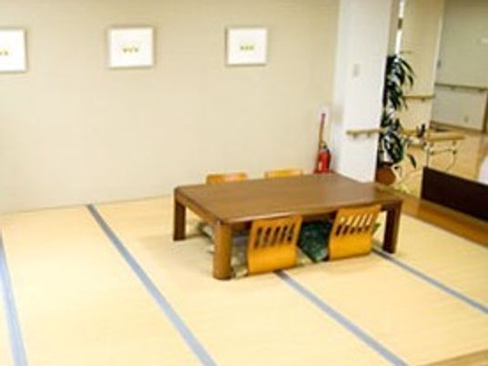 畳敷きのスペースに座いすを4脚セットした和風の机が置かれている。