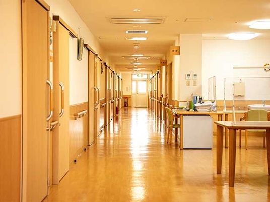 廊下はまっすぐで幅が広く、居室のドアと木製の手すりが両サイドに設置されている。