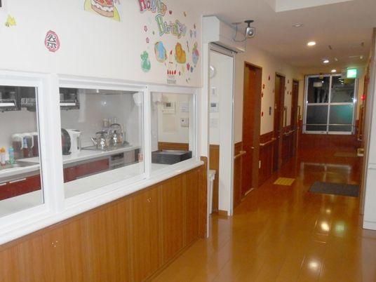 廊下からはキッチンを見ることができる。手すりが付き安全に移動できる廊下。