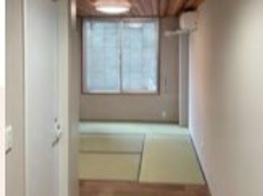 たた敷きの部屋が奥にあり、エアコンが付いている。手前にはフローリングの廊下がある。