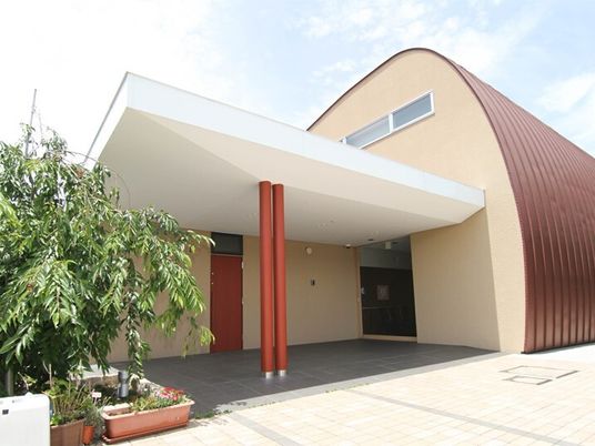 丸いドームのような形をした外観が印象的な建物。グループホーム万葉の外観