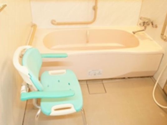 家庭的なサイズの浴室の様子。シャワーチェアが置いてある高齢者用浴室の写真
