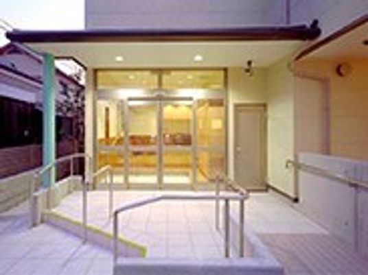 明かりが灯った屋根付きの玄関には自動ドアがつき、手すり付きのスロープもある。