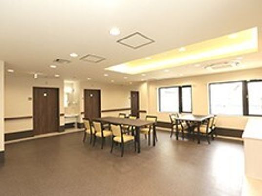 リビングダイニングには二組のダイニングテーブルセットが置かれ、壁には手すりが付いている。