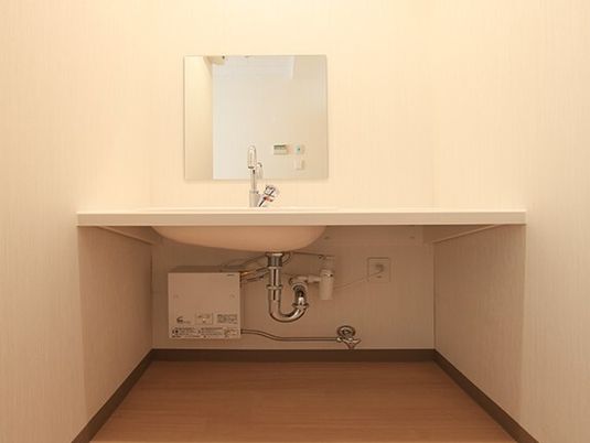 足を下に入れられるフットレス設計の洗面台の様子。施設内の設備の写真