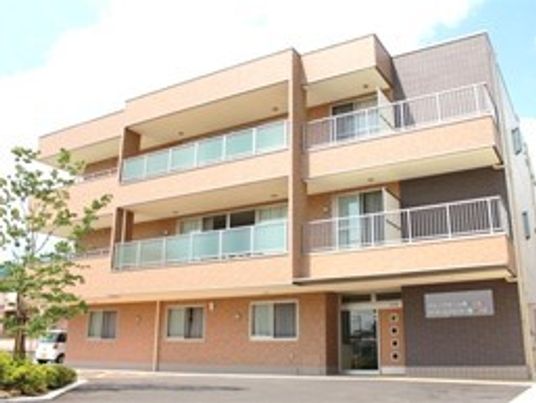 3階建ての建物の2階と3階にはベランダが付き、ブラウン系でまとめられている。