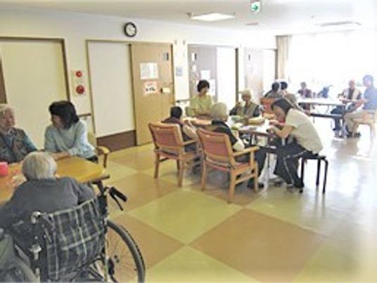 ダイニングテーブルに座り楽しそうに話をしているスタッフと入居者。