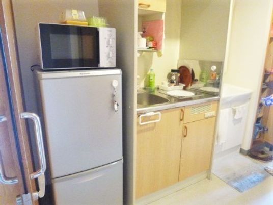 冷蔵庫が置いてある施設内の居室の様子。小さなキッチンスペースがある居室