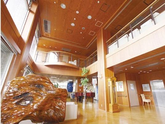 開放的な施設内の吹き抜け部分の様子。手前に木の置物があるスペース