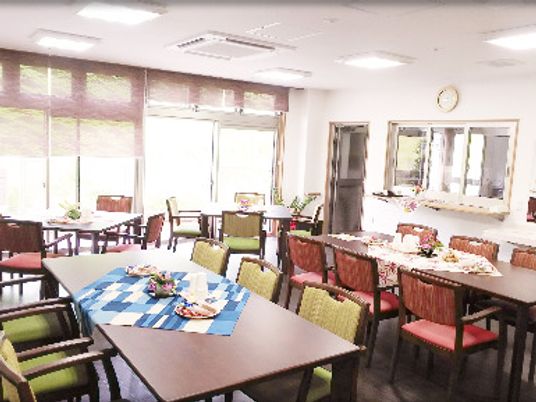 赤や緑の椅子が設置されたダイイングテーブルが複数置かれた食堂は大きな窓が付いている。