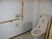 L字型の手すりが付いたトイレの様子。高齢者用の設備が見えている
