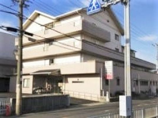 鉄骨造4階建ての建物の写真。スロープ付きのエントランス部分が見えている