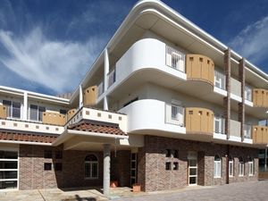３階建ての建物は白とベージュ、ブラウンでまとめられ落ち着いた雰囲気。各フロアにベランダもある。