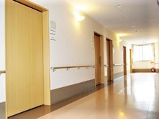 手すりが付いた廊下はまっすぐで突き当りに大きな窓があり、居室のドアは大きな引き戸となっている。