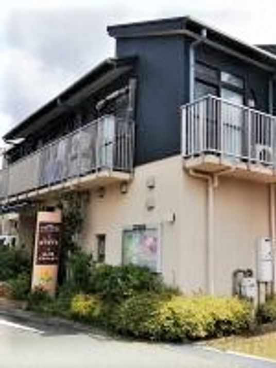 ツートンカラーの建物の外観写真。グループホームあそびりクラブ西小路の家の外観