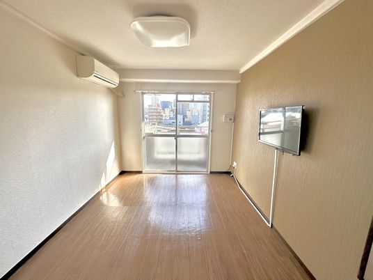 エアコン、ナースコール、照明器具、薄型テレビが設置されているフローリングの洋室