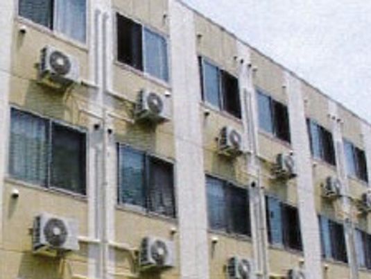 部屋の外にエアコンの室外機が取り付けてある。部屋が並んでいる様子が分かる。