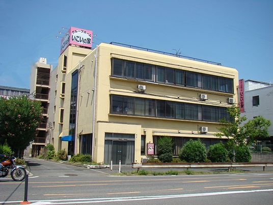 鉄骨造３階建ての建物の外観。道路沿いに建っているマンションのような建物の写真