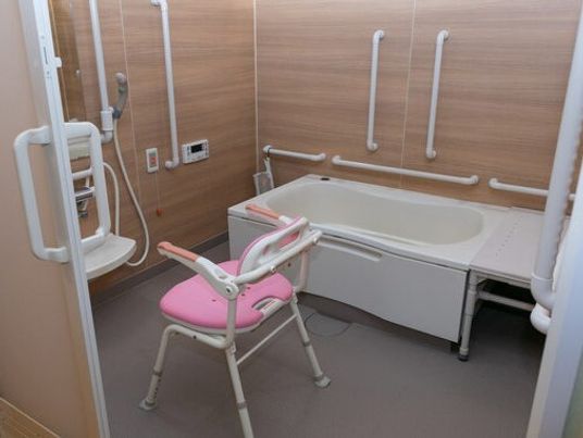 シャワーチェアや手すりがついた介護仕様の設備の写真。施設内の浴室の様子