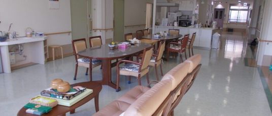 茶色いテーブルと複数の椅子が2セット、ソファ、オセロや将棋などが置かれているテーブル