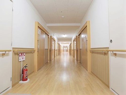 廊下は広く段差もない造りで両サイドに手すりが付いている。手前には消火器も設置されている。