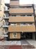 5階建ての建物はブラウン系で重厚感があり、建物の前には駐車場もある。