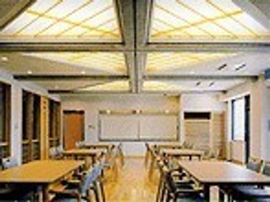 天井の高い共有スペースの一つ。広めの空間にテーブルが並んでいるのが分かる
