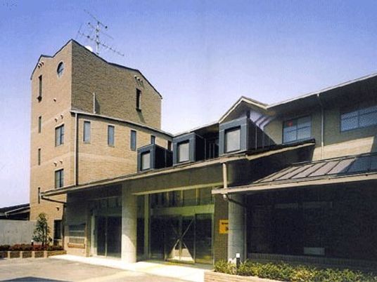古い駅舎のようなデザインの建物が写っている写真。シックな色合いの広めの建物