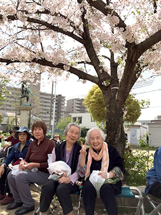 花見に出ている高齢者とスタッフの様子。施設内で行われているレクリエーション