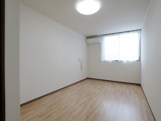 フローリングの部屋には照明やエアコン、緊急通報装置があり、おおきな窓が付いている。