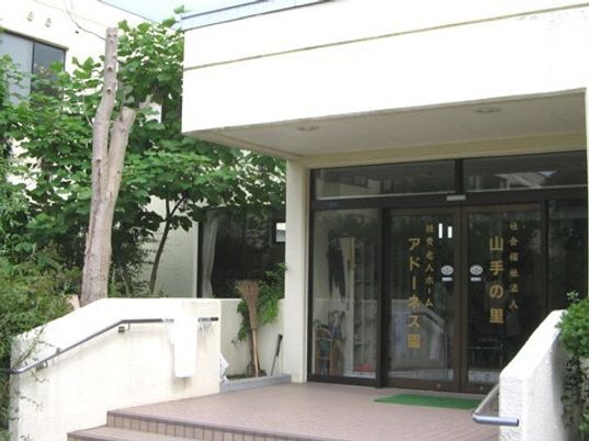 白を基調とした建物には自動ドアが付き、ハウス名が書かれている。