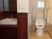家具調の洗面所の奥には背もたれや可動式の手すりが設置されたトイレがある。