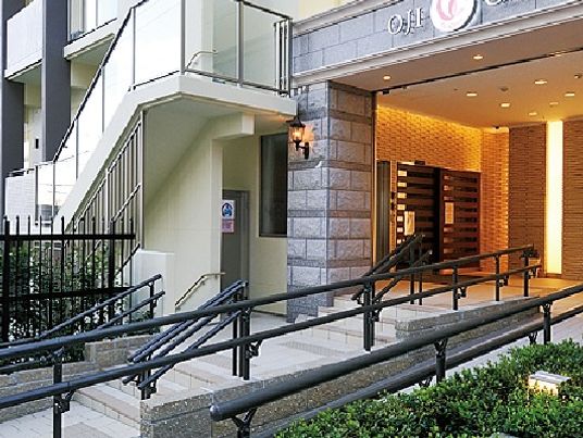 提携クリニックの外観。大きな建物の立派なエントランスにはスロープと階段が設置されている。